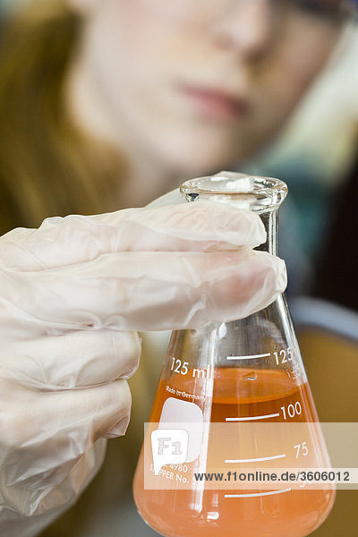 Forscher halten Becher mit Chemikalien gefüllt