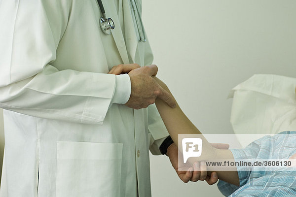 Arzt untersucht den Arm des Patienten
