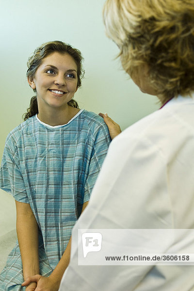 Patient lächelt erleichtert und erhält gute Nachrichten vom Arzt