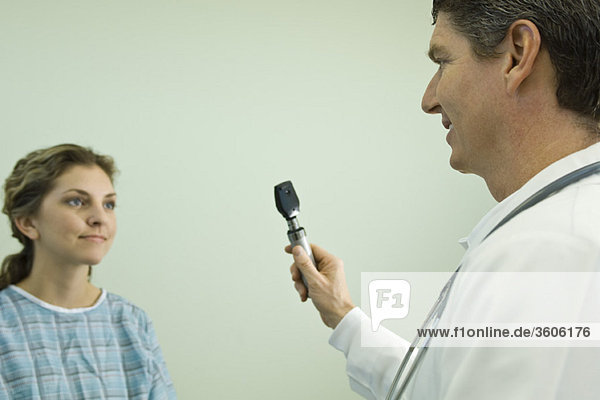 Arzt mit Ophthalmoskop bei der medizinischen Untersuchung