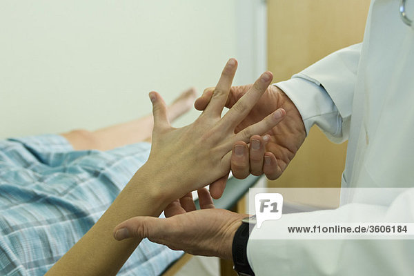 Doctor examining patient's hand