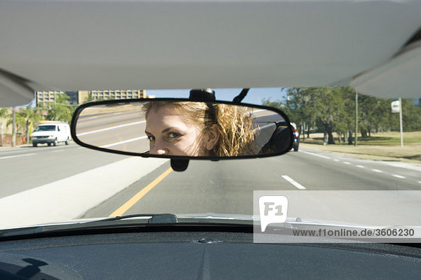 Woman driving  checking rear view mirror