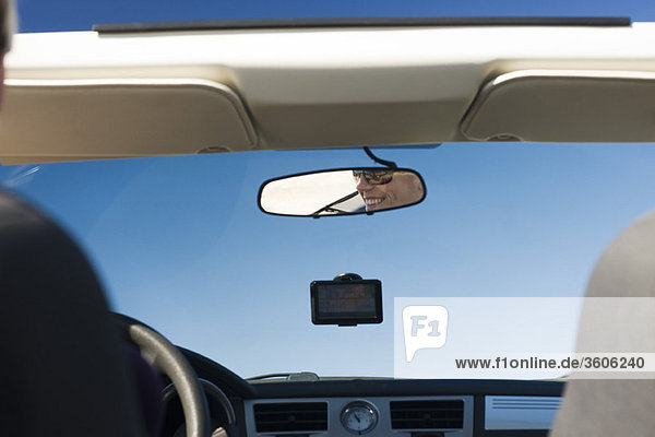 Frau fährt Auto  Spiegelung im Rückspiegel