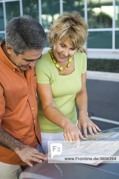 Ein reifes Paar schaut sich gemeinsam die Straßenkarte an und bespricht die Route für die Reise.