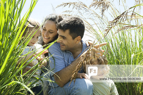 Family crouching together in tall grass