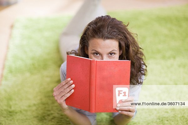 Frau versteckt sich hinter einem Buch