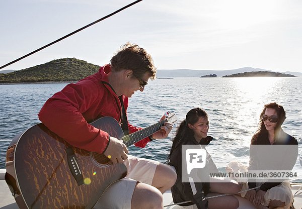 Friends with guitar on yacht