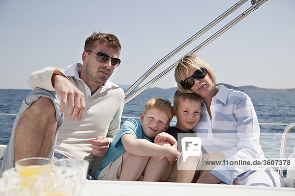 Familie sitzt zusammen auf der Yacht