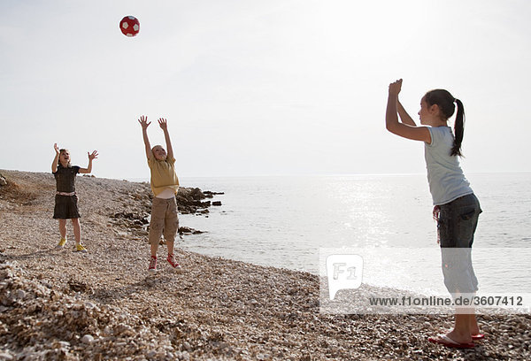 Kinder beim Ballspielen am Strand