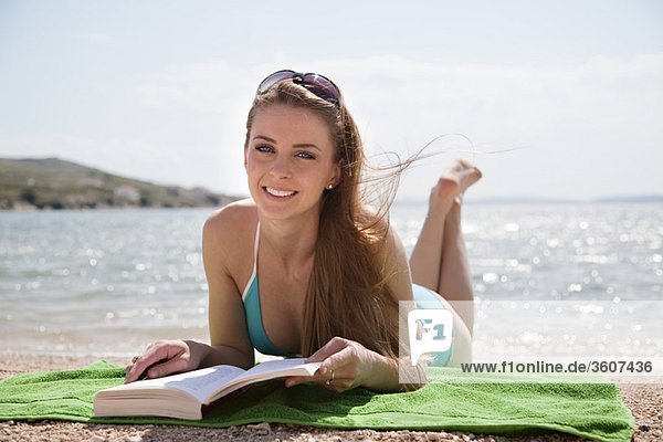 Frau beim Lesen am Strand