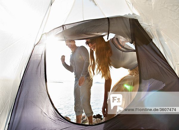 Couple with tent by sea