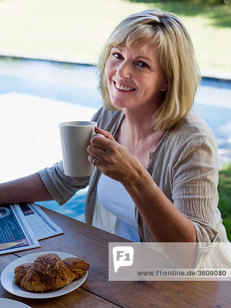 Woman outdoors with coffee and breakfast