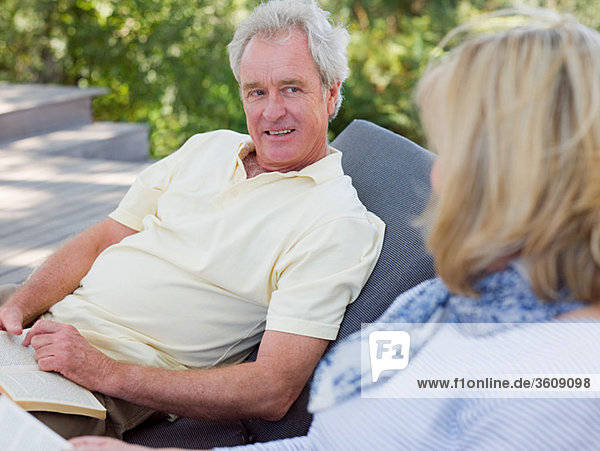 Mature couple on loungers in garden