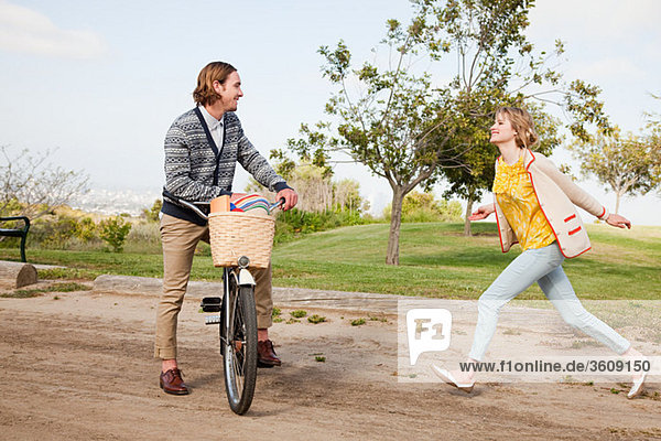 Junge Frau  die mit dem Fahrrad zum Freund rennt
