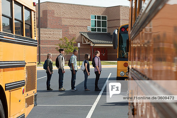 Gymnasiasten in der Schlange für den Schulbus