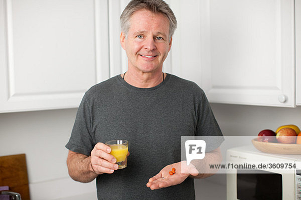 Mann mit Vitaminen und Orangensaft