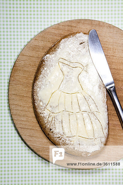Scheibe Brot mit Frischkäse auf einem Brettchen