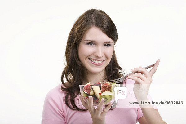 Young woman eating fruit salad