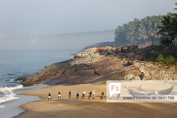 Fischer ziehen Netz ein, Strand südlich von Kovalam, hinten Vizhinjam, Malabarküste, Malabar, Kerala, Südindien, Indien, Asien