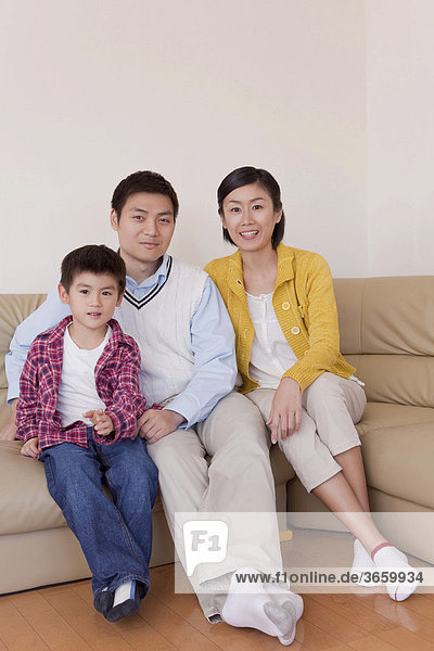 Familie sitzt auf dem Sofa