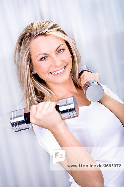 Young woman training with dumbbells