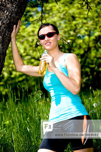 Junge Frau trinkt nach dem Lauf