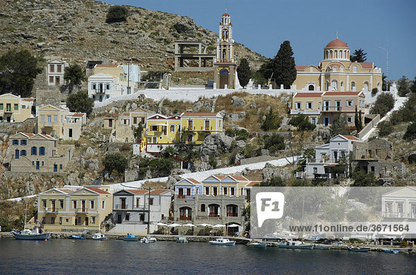 Blick auf die farbenfrohen ockerfarbenen Häuser der Insel Symi Griechenland