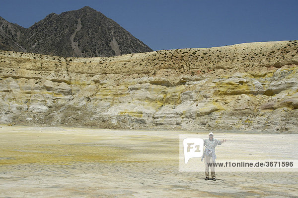 Aktive Senioren Frau steht im schwefel gelben Stefanos Krater Insel Nissyros Griechenland