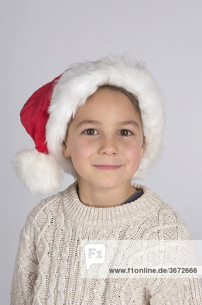 Kleiner Junge mit Nikolausmütze an Weihnachten