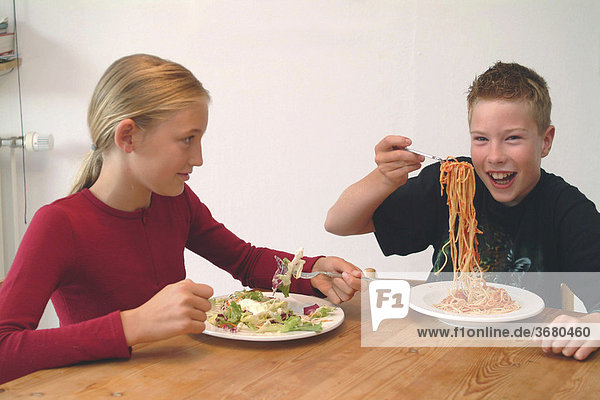 Kinder beim spagetti + salat essen