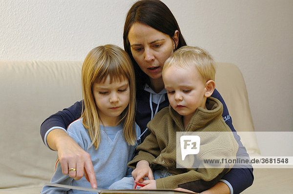 Mother and children reading a book