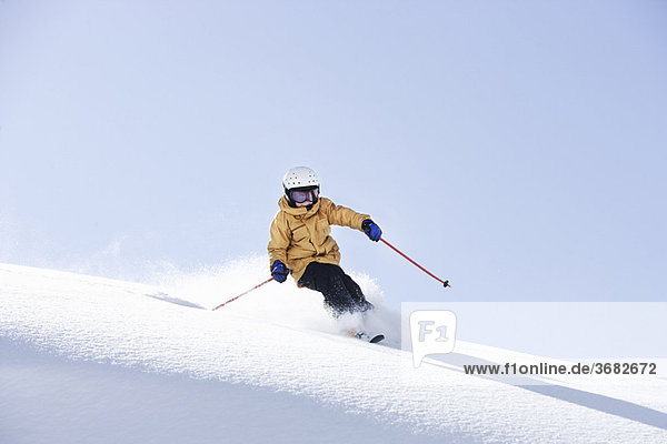 Kleiner Junge beim Skifahren im frischen Pulverschnee