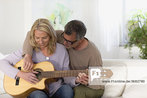 Mann und Frau klimpern Gitarre