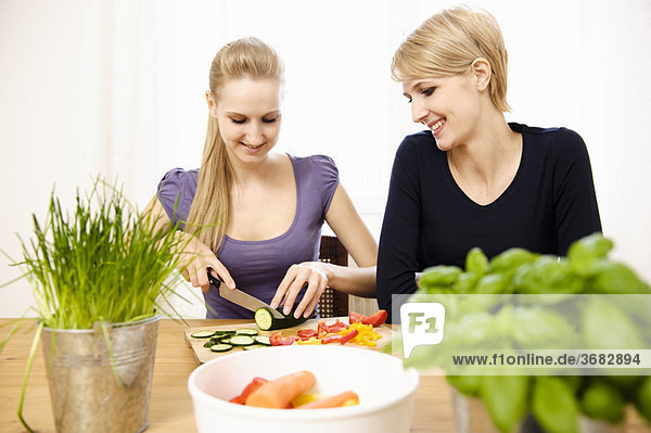 Junge Frauen beim Zubereiten von Speisen  Essen und Trinken