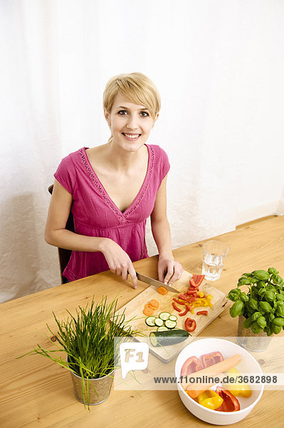 Junge Frau zu Hause beim Zubereiten von Speisen