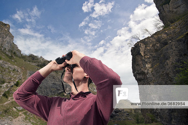 Man in valley with binoculars