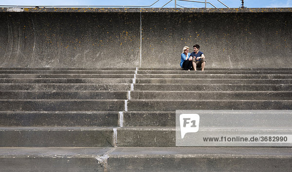 Paar sitzt zusammen auf einer Treppe
