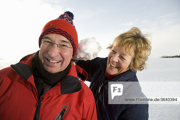 Seniorenpaar mit Schneeball