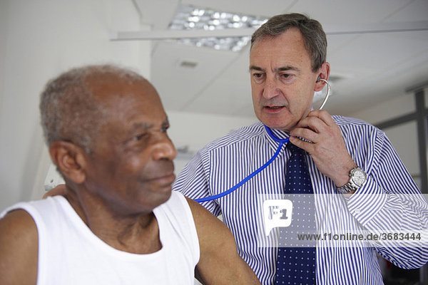 Doctor with stethoscope with elderly man