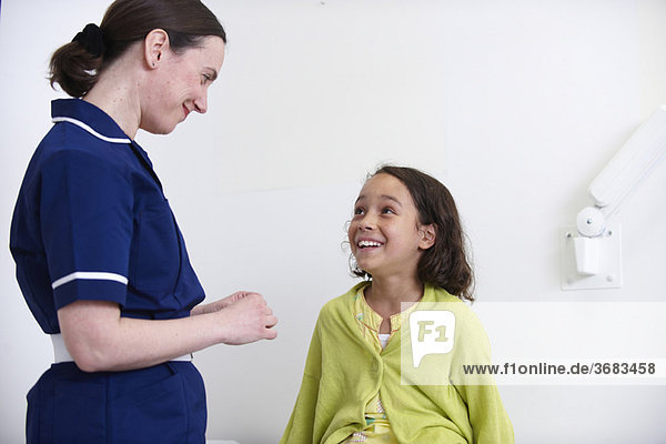 Nurse and young girl smiling