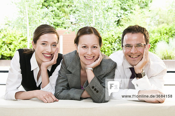 3 glückliche Kollegen lächeln vor der Kamera
