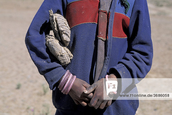 Kind mit getrocknetem Mist unter dem Arm Tibet