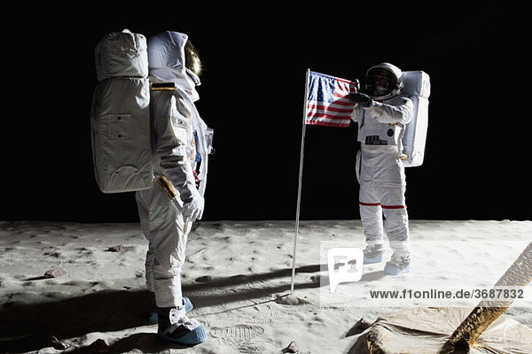 Zwei Astronauten auf dem Mond  dazwischen eine amerikanische Flagge.