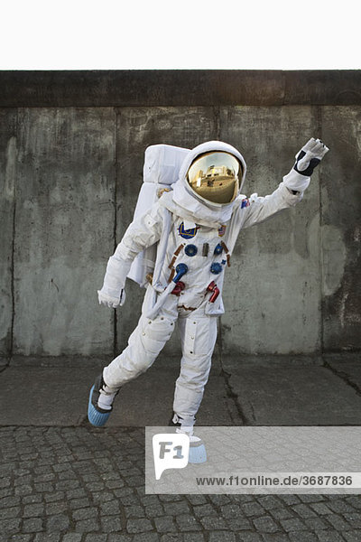 Ein Astronaut auf einem Bürgersteig  der vorgibt  im Flug zu starten.