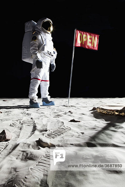 Ein Astronaut auf dem Mond neben einer Fahne mit OPEN drauf.