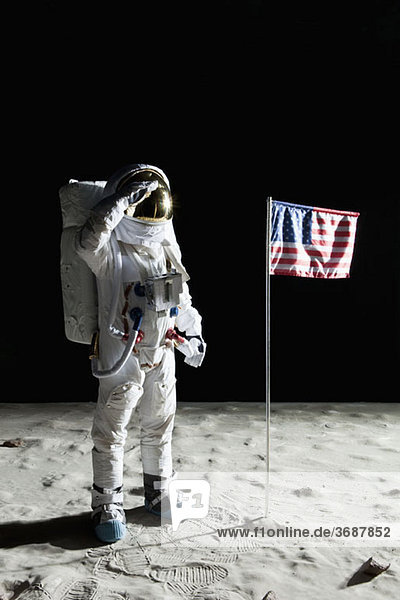 Ein Astronaut auf der Oberfläche des Mondes  der eine amerikanische Flagge salutiert.