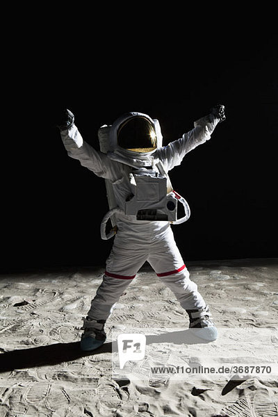 Ein Astronaut auf dem Mond mit erhobenen Armen im Sieg
