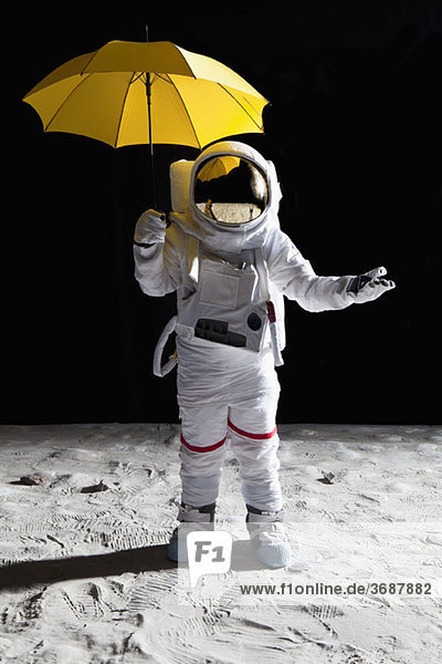 Ein Astronaut auf dem Mond mit einem Regenschirm