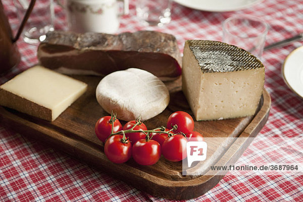 Käse  Tomaten und Rohschinken auf einem Holzschneidebrett