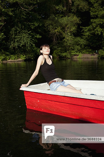 Eine junge Frau beim Sonnenbaden im Ruderboot